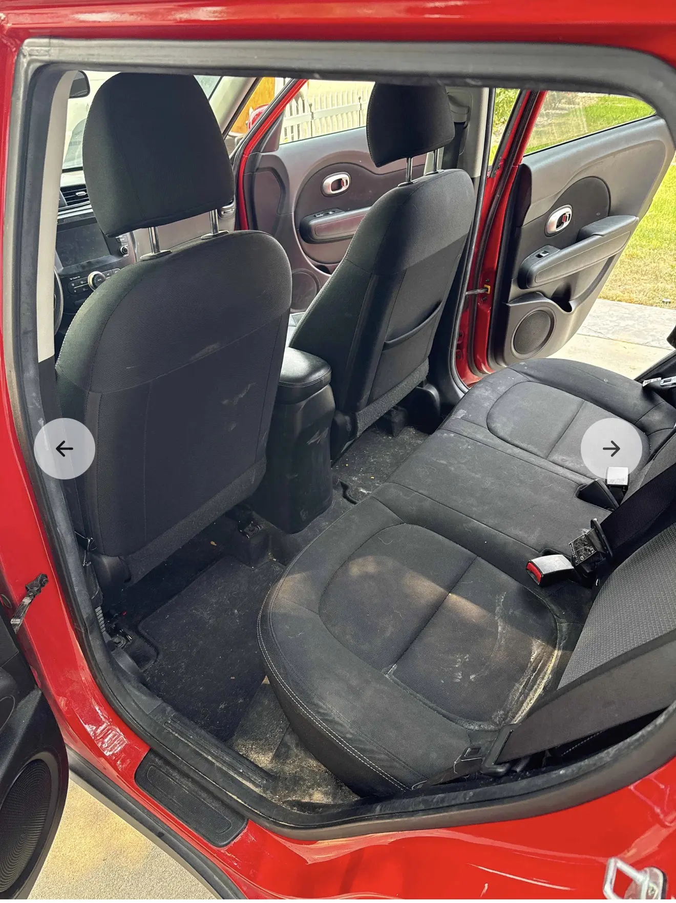 Rear seats of a red Kia Soul covered in sand and mud before detailing
